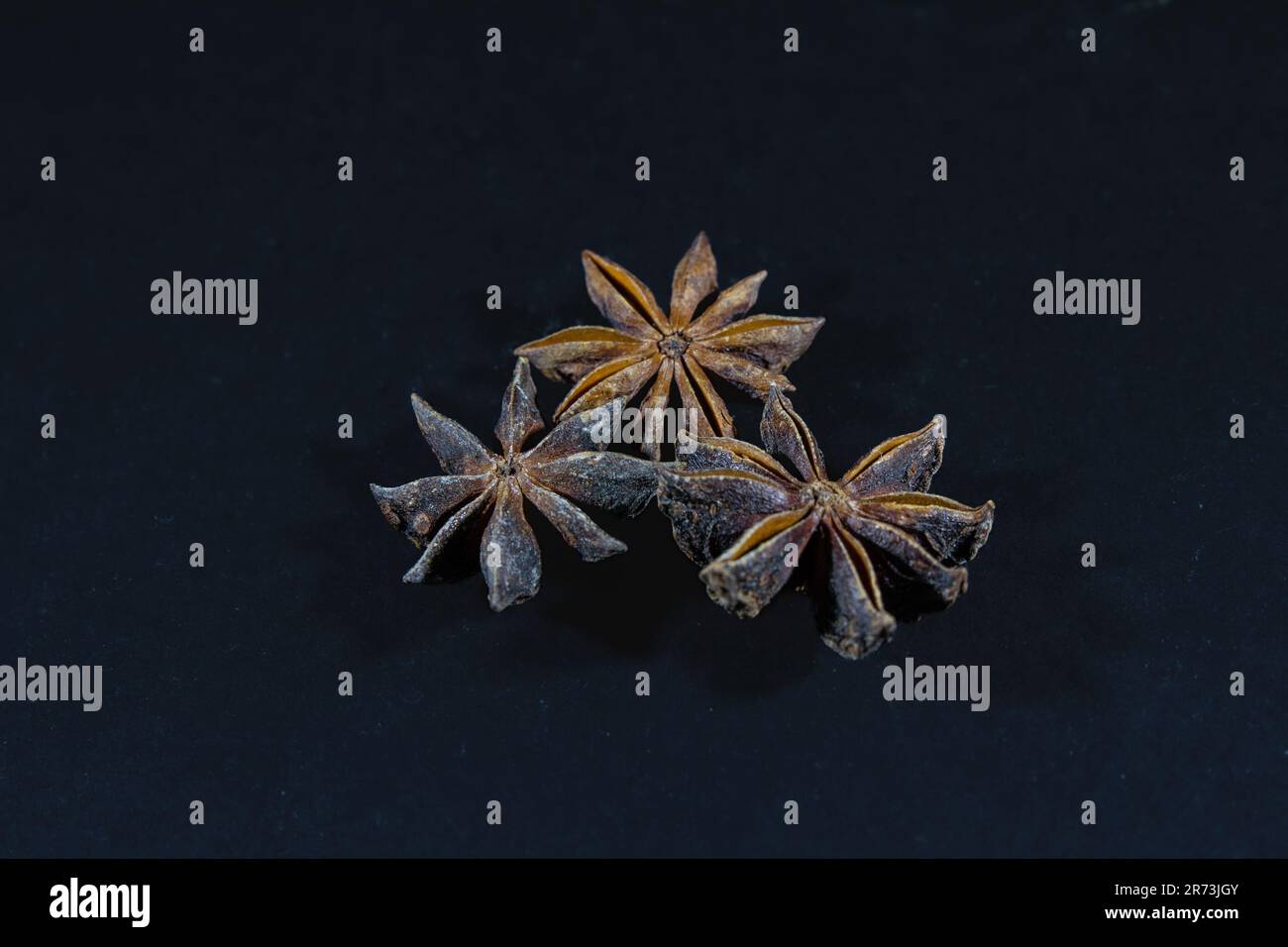 Picture of a star anise on a black background. Anise, also called aniseed or rarely anix is a flowering plant in the family Apiaceae native to the eas Stock Photo