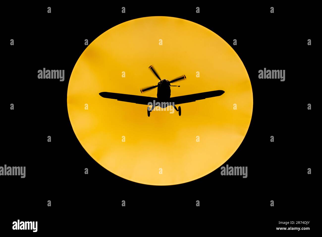 Digitally enhanced image of a silhouette of a propellor plane in front of the full moon Stock