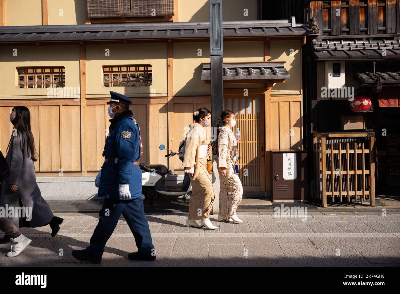 A group of police officers in uniform strolling down a vibrant city street in c Stock Photo