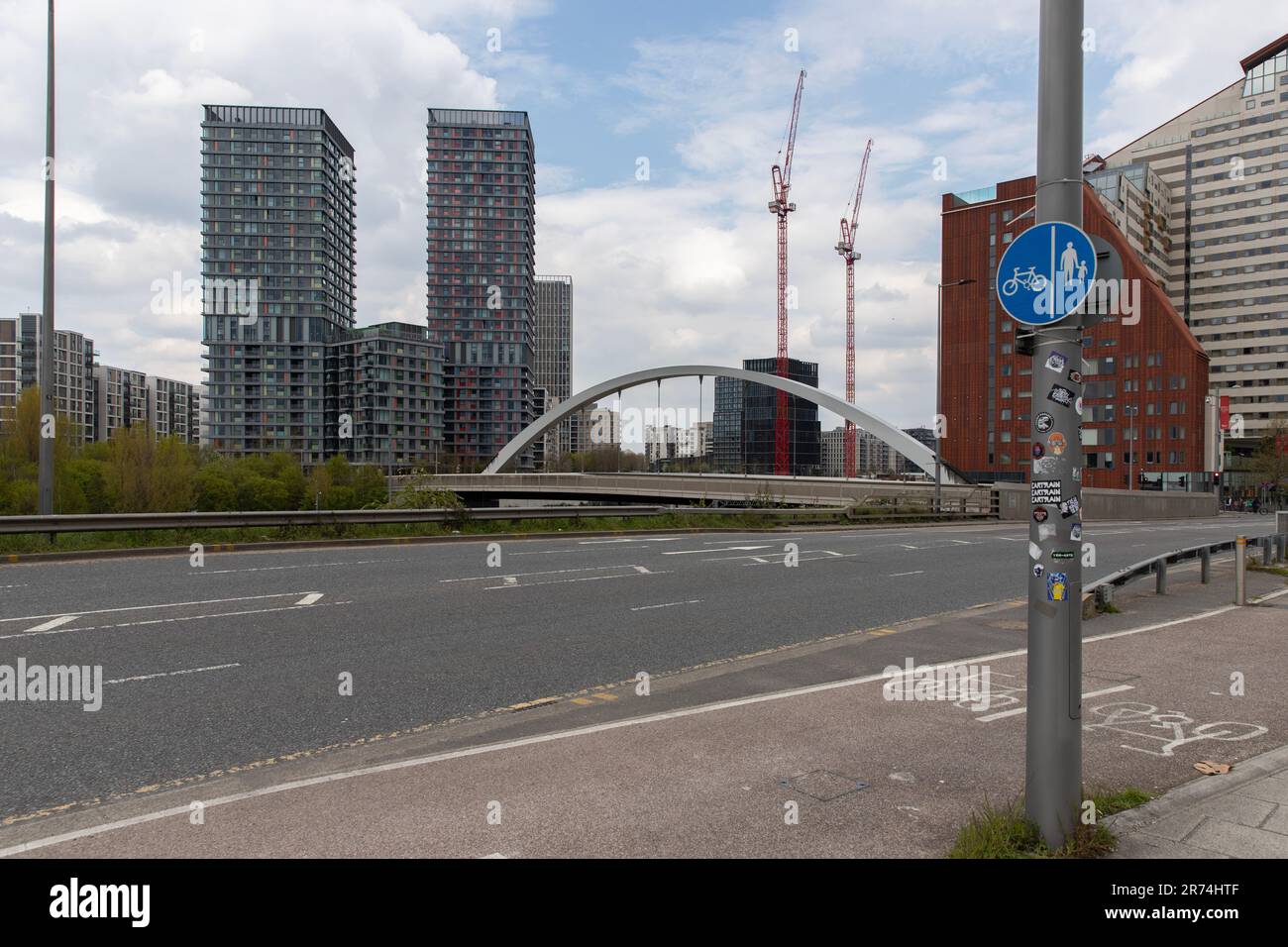 Waterden Road, Queen Elizabeth Olympic Park, Stratford, east London, with Olympic Park Avenue curved bridge and buildings in background. Stock Photo