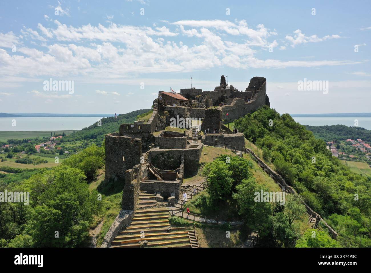 A majestic castle perched atop a hill, surrounded by lush green grass ...