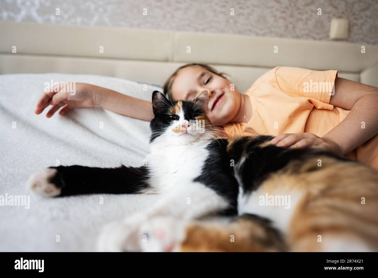 Cute little girl lying on the bed with her cat at home Stock Photo - Alamy