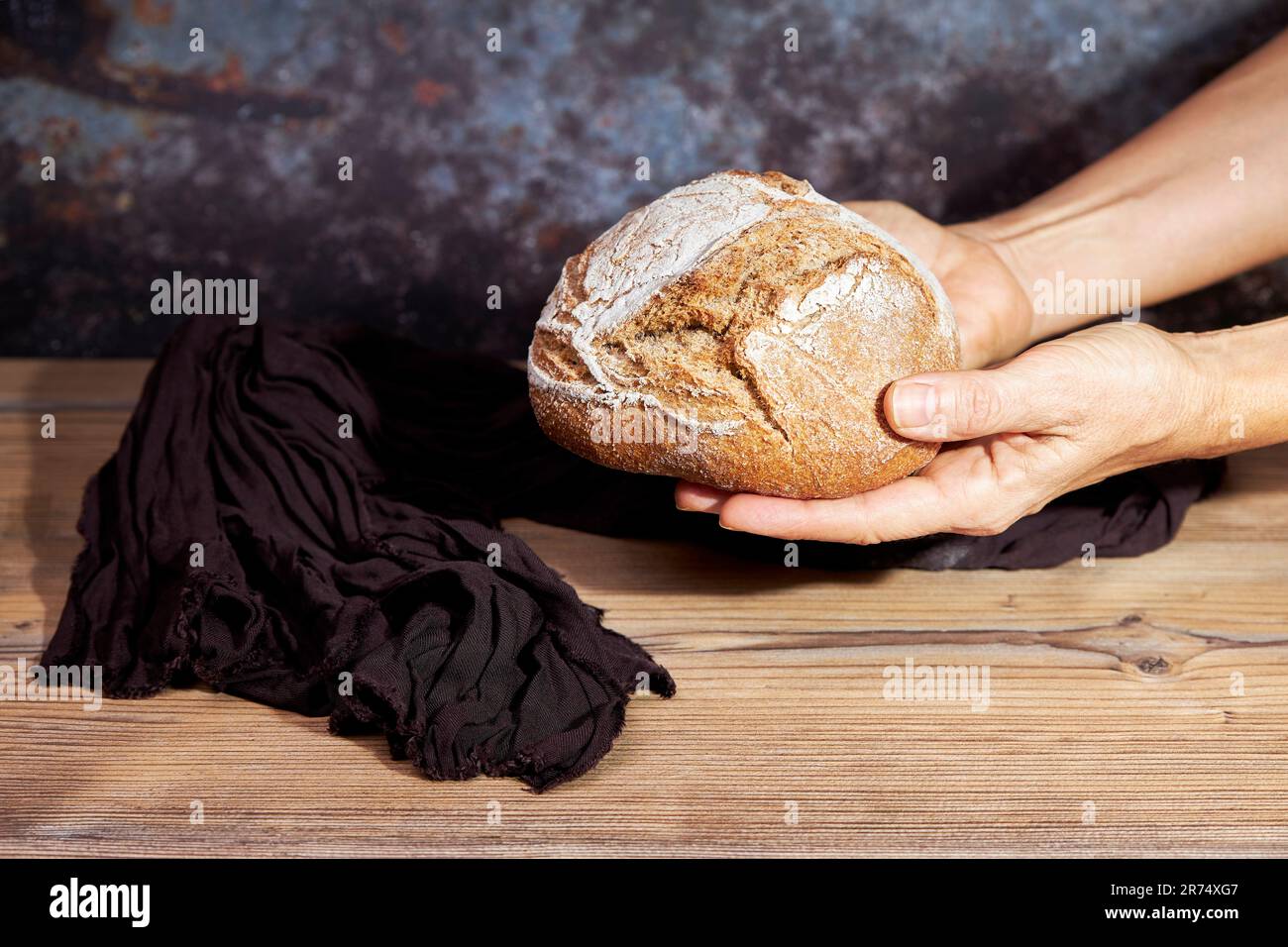 Hands of woman holding a golden loaf of bread. Food concept Stock Photo