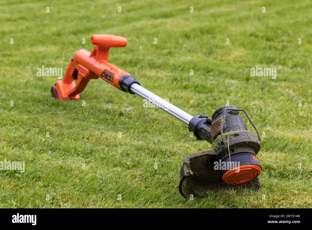 https://c8.alamy.com/comp/2R7514B/black-decker-cordless-lawn-trimmer-is-on-lawn-lawn-care-garden-2R7514B.jpg