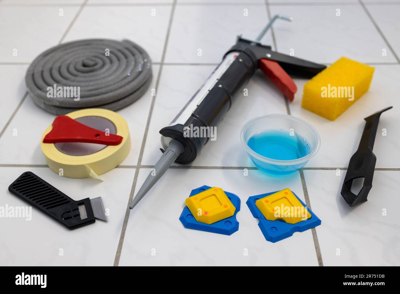 Cartridge press lies on floor tile, renew silicone joint in floor area, work material, Stock Photo