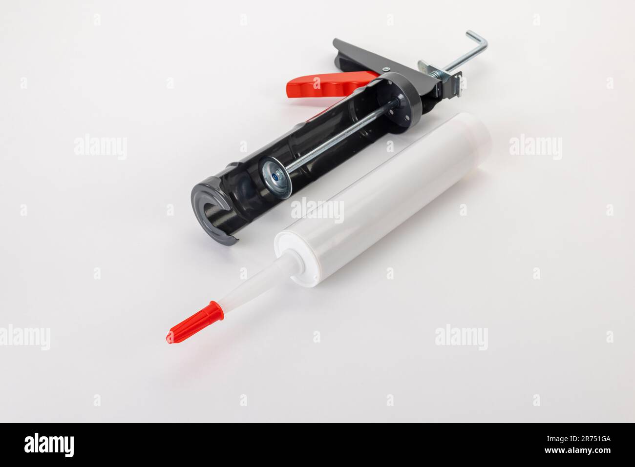 Half shell cartridge press lying in front of it silicone cartridge without labeling, white background, Stock Photo