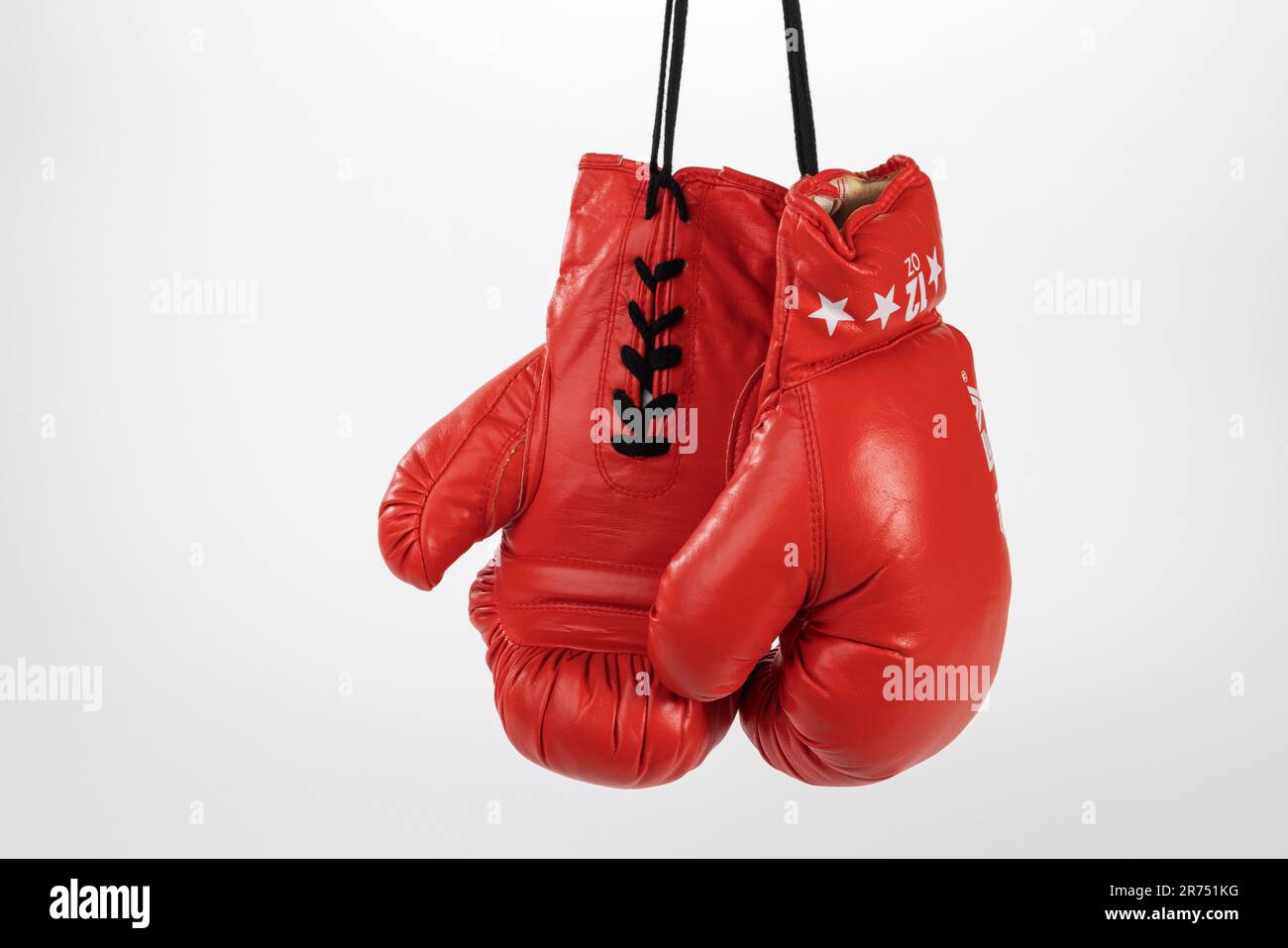 Pair of red boxing gloves hung on lace, white background, Stock Photo