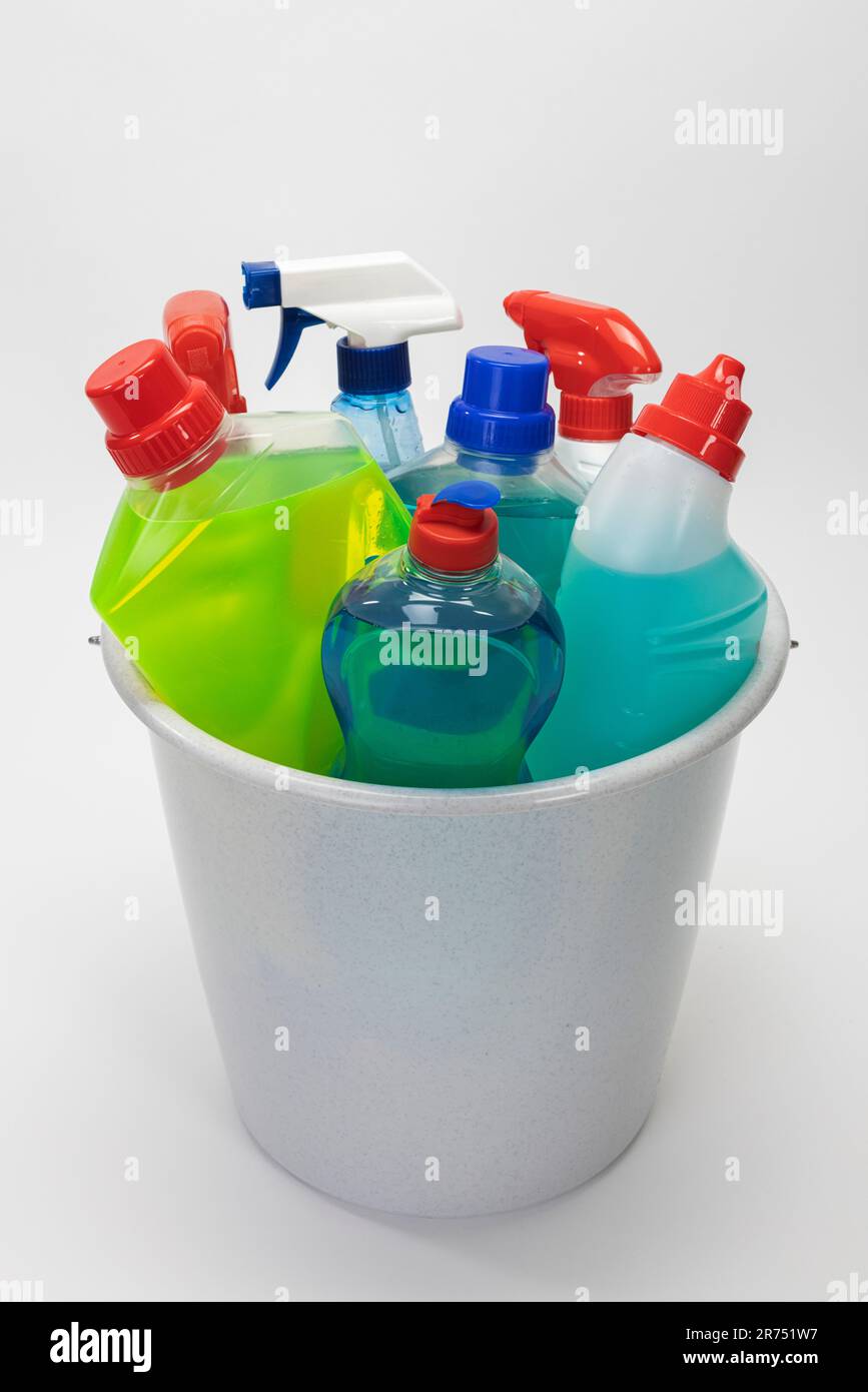 Gray cleaning bucket filled with various cleaning products, white background, Stock Photo