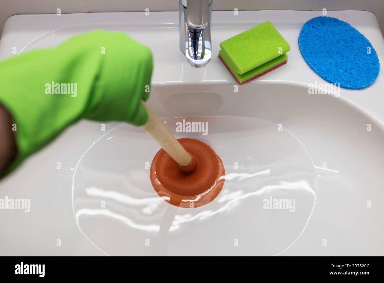 Sink, Clogged drain, unclog with the plunger Stock Photo Alamy