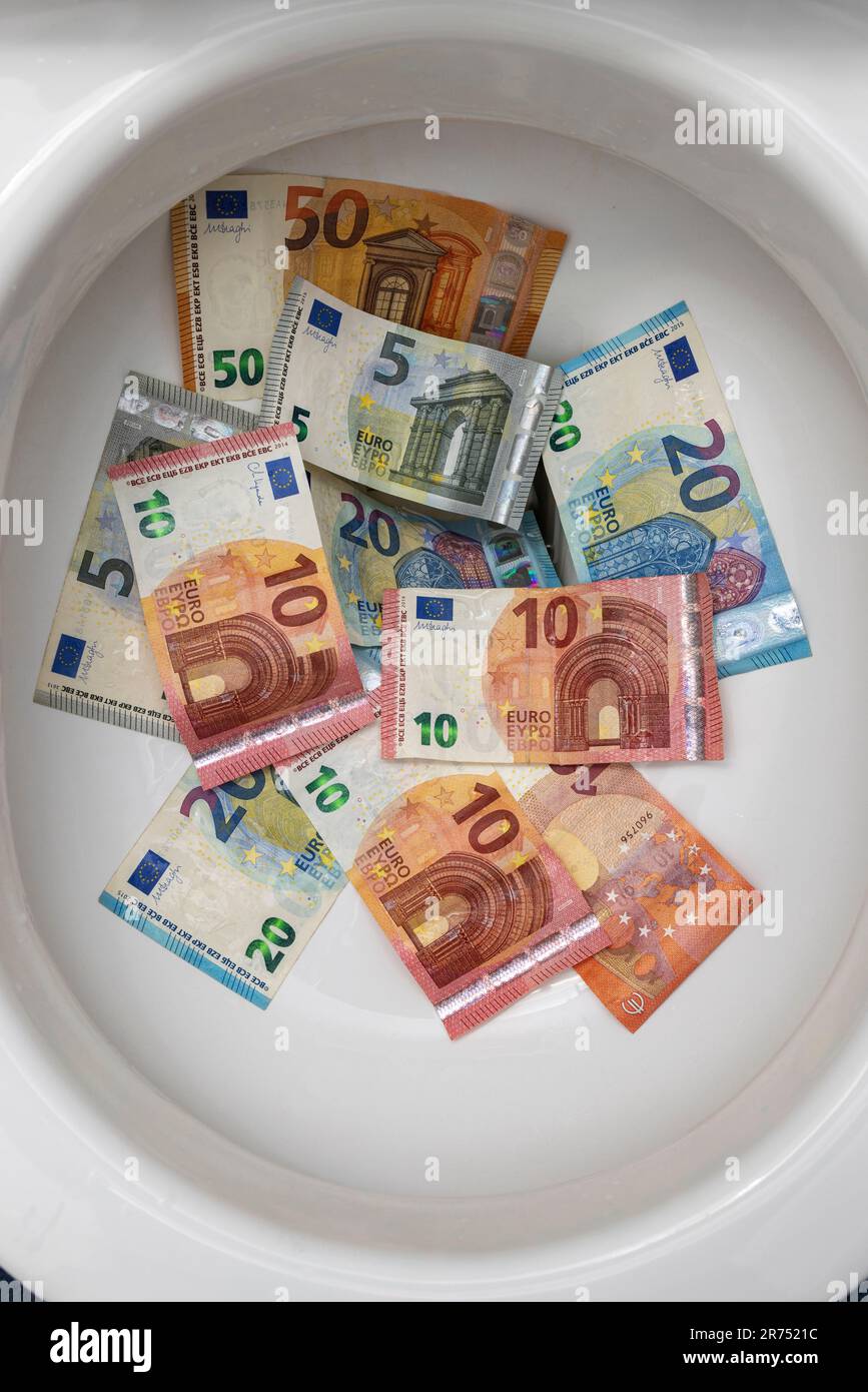 Various euro bills in the toilet bowl, water consumption, Stock Photo