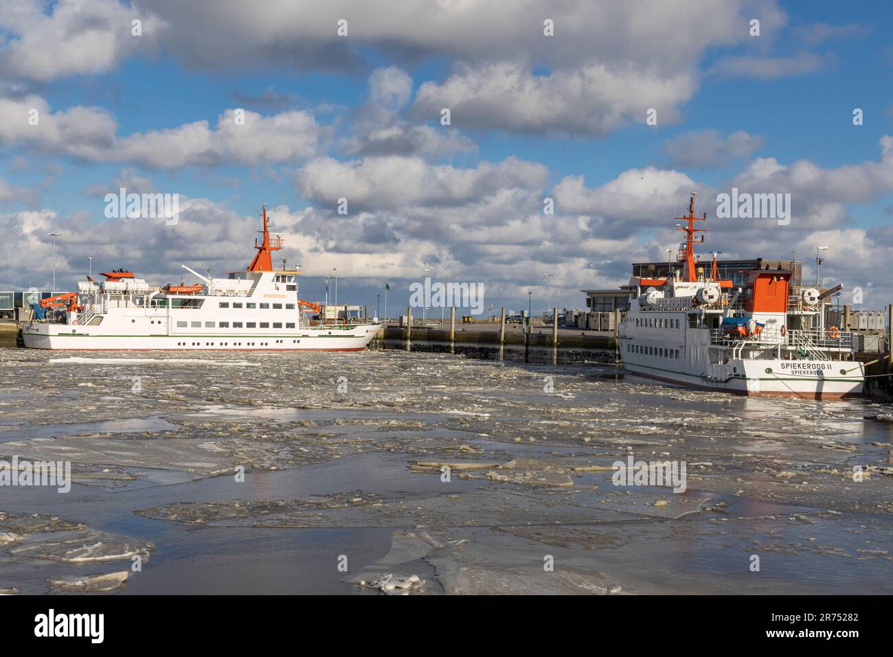 Winter atmosphere, icy harbor, ferry ship 'Spiekeroog I' and ferry ship 'Spiekeroog II' lying in the ferry harbor of Neuharlingersiel, East Frisia, Lower Saxony, Stock Photo