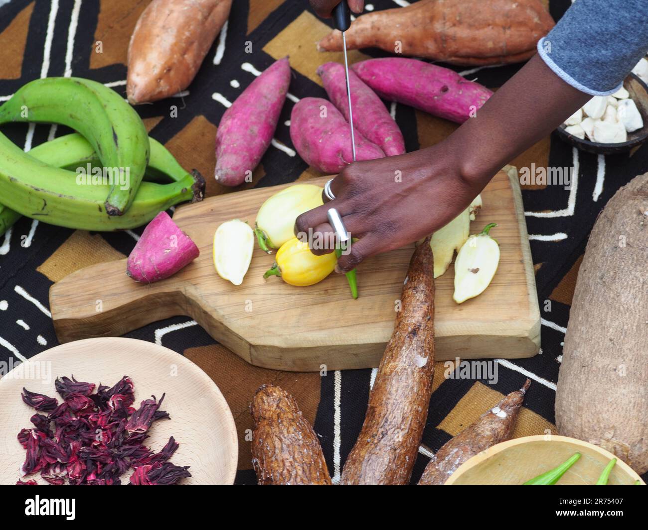 black woman cutting typical african veggies and fruits, overhead shot. Cooking Ivory coast local food. Stock Photo
