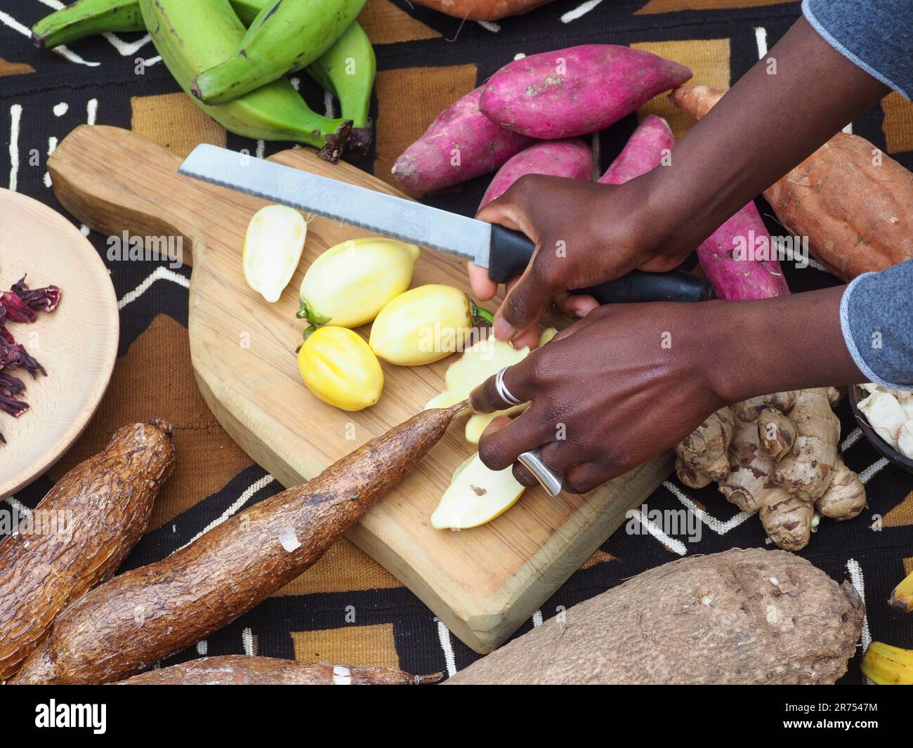 black woman cutting typical african veggies and fruits, overhead shot. Cooking Ivory coast local food. Stock Photo