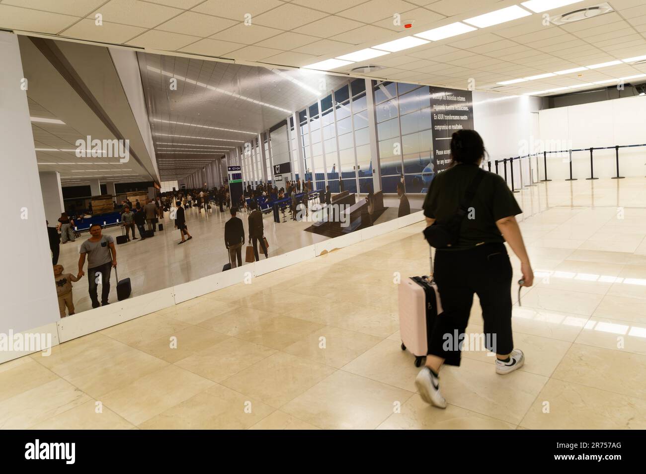 Passengers walking alomg corridor inside Merida airport, Mexico Stock Photo