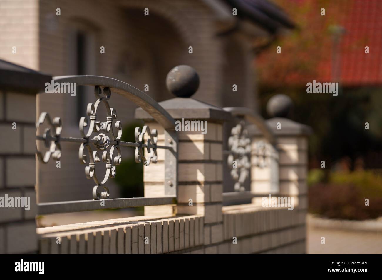 Brick fence with forged iron lattice. Rural landscape, soft focus Stock ...