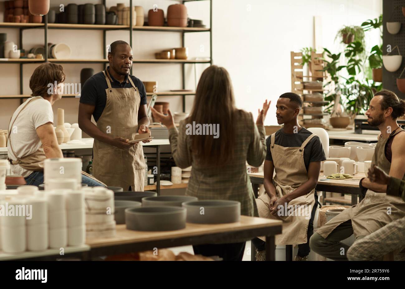 Manager talking with her team in a ceramics studio Stock Photo