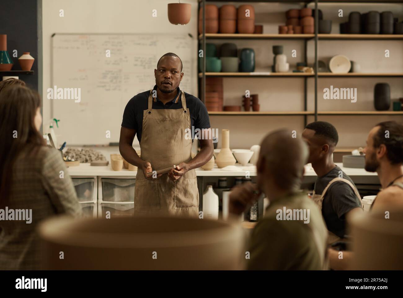 Diverse group of ceramists talking during a meeting in a studio Stock ...