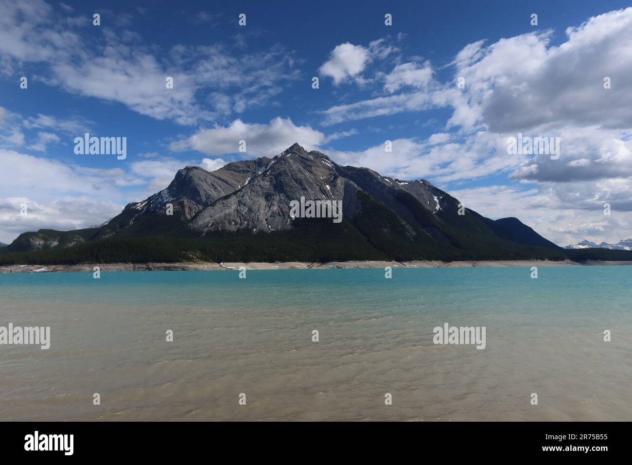 A scenic view of a majestic lake surrounded by towering mountain peaks ...