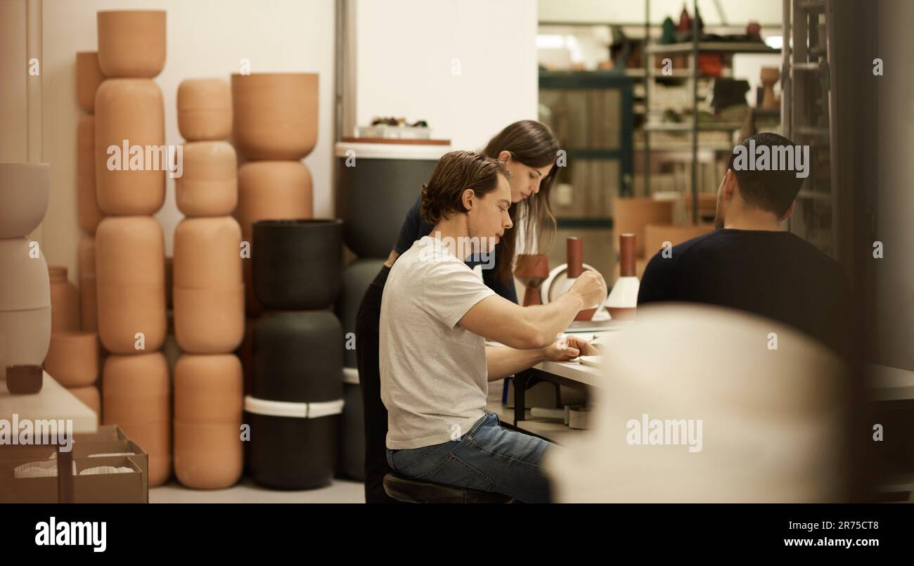 Ceramics designers talking together at a studio table Stock Photo