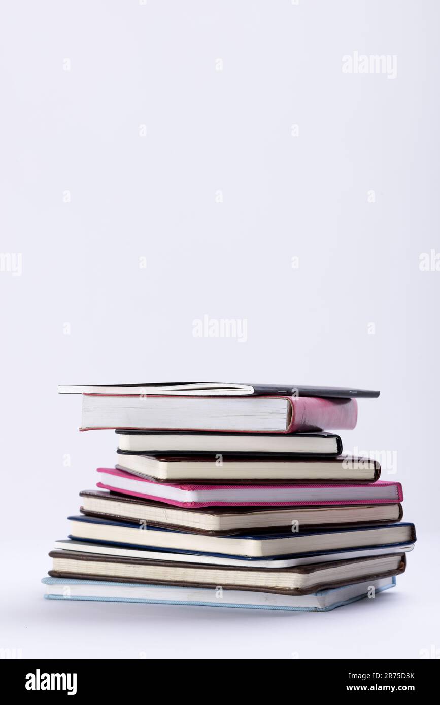 Close up of stack of books and notebooks with copy space on white