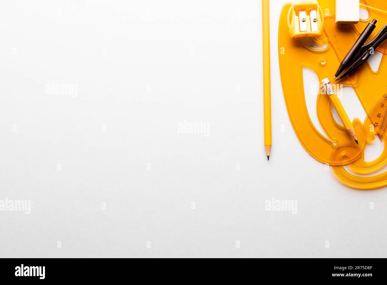 Close up of yellow rulers, compass and sharpener on white background ...
