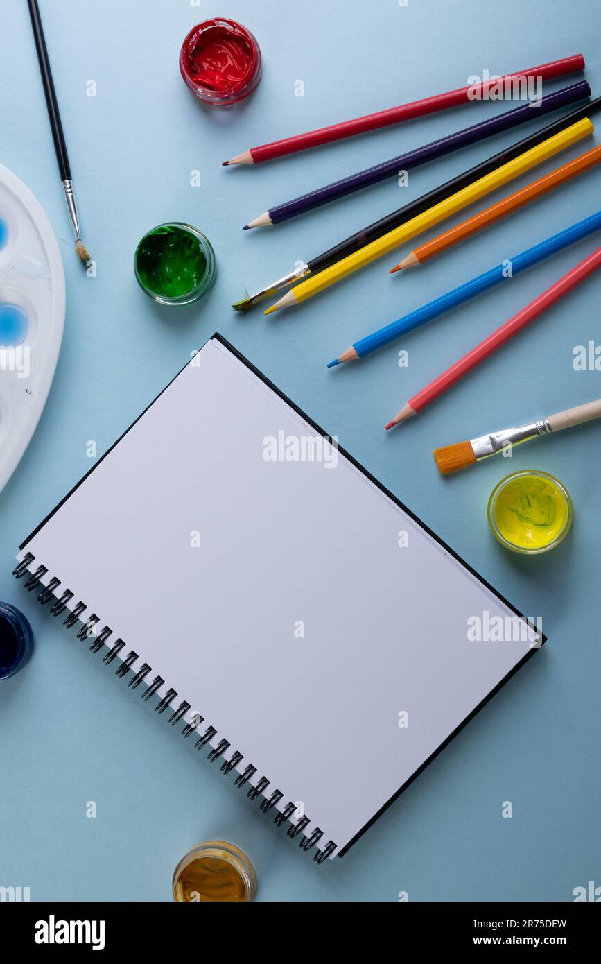 Close up of paints, pencils, notebook and brushes with copy space on