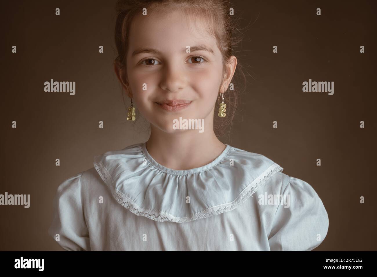 Beautiful clever, little girl, studio portrait on brown background Stock Photo