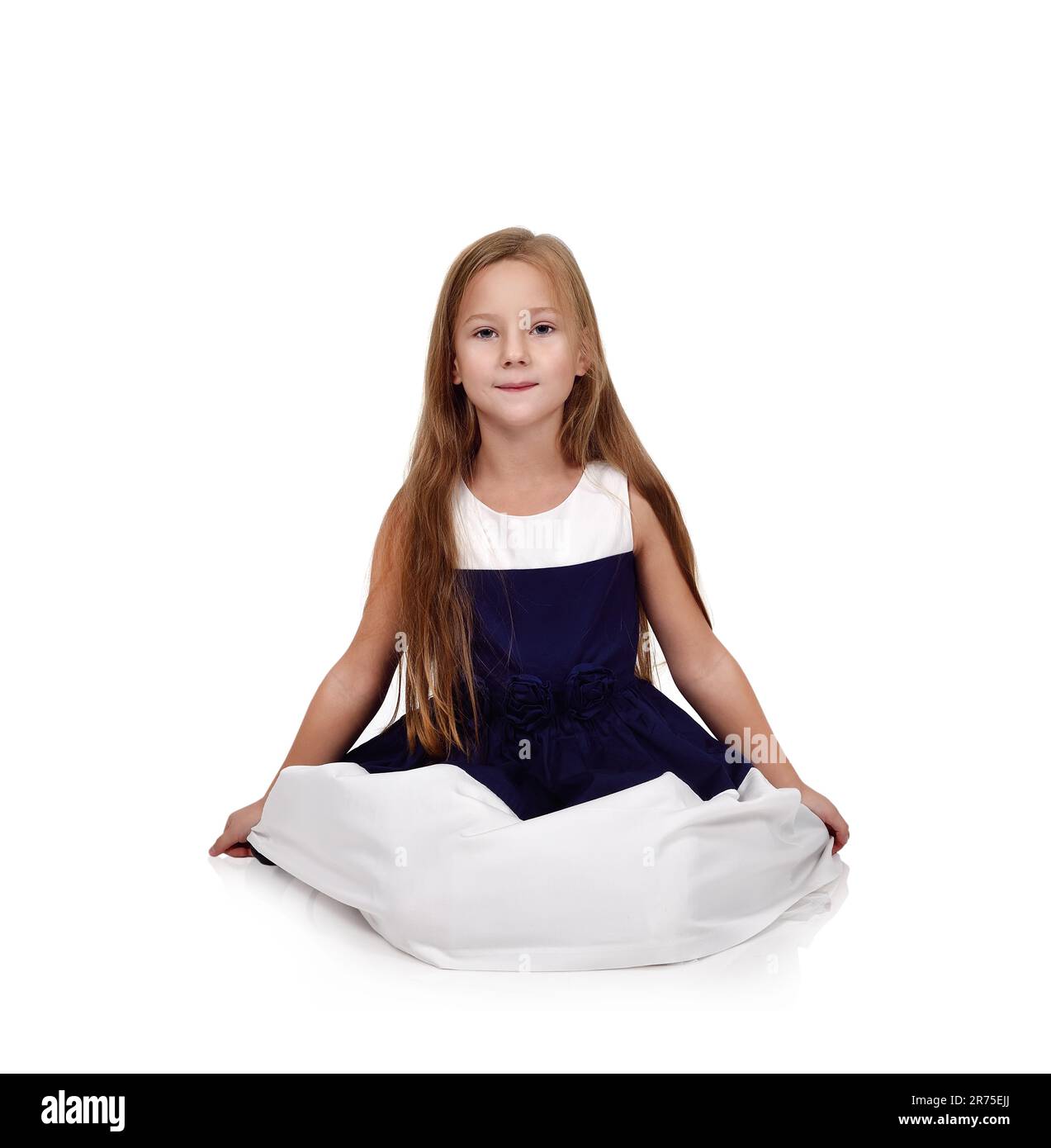 Cute young girl in blue dress sitting on floor Stock Photo - Alamy
