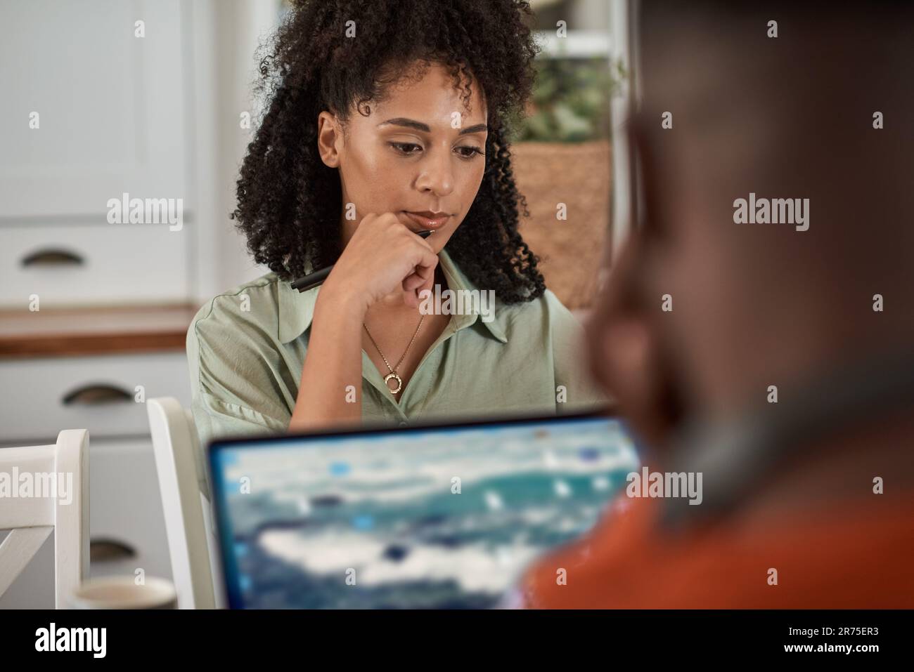 Multiracial couple using laptops while working remotely from home Stock Photo