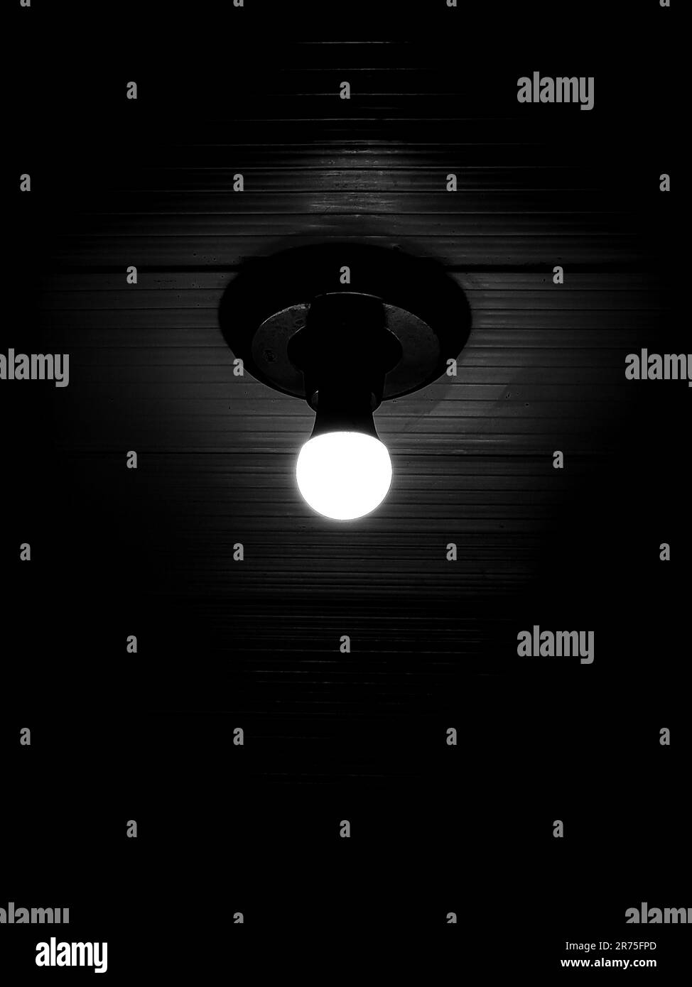 An illuminated ceiling in a dark room, illuminated by a single, bright