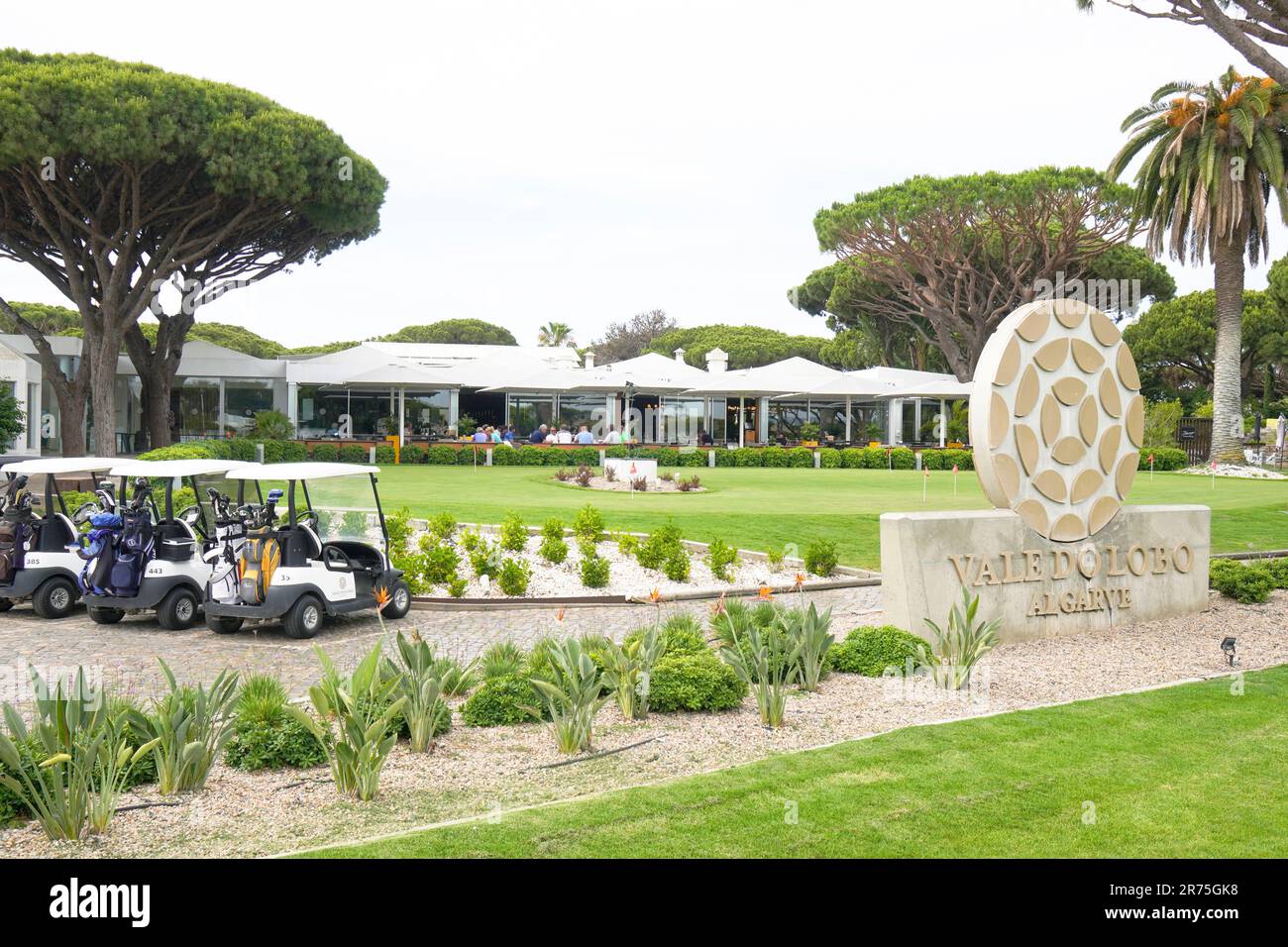 Welcome sign at Vale do Lobo golf club and course, with golf buggies and golf clubs, and a view to the club house and restaurant, algarve, portugal. Stock Photo