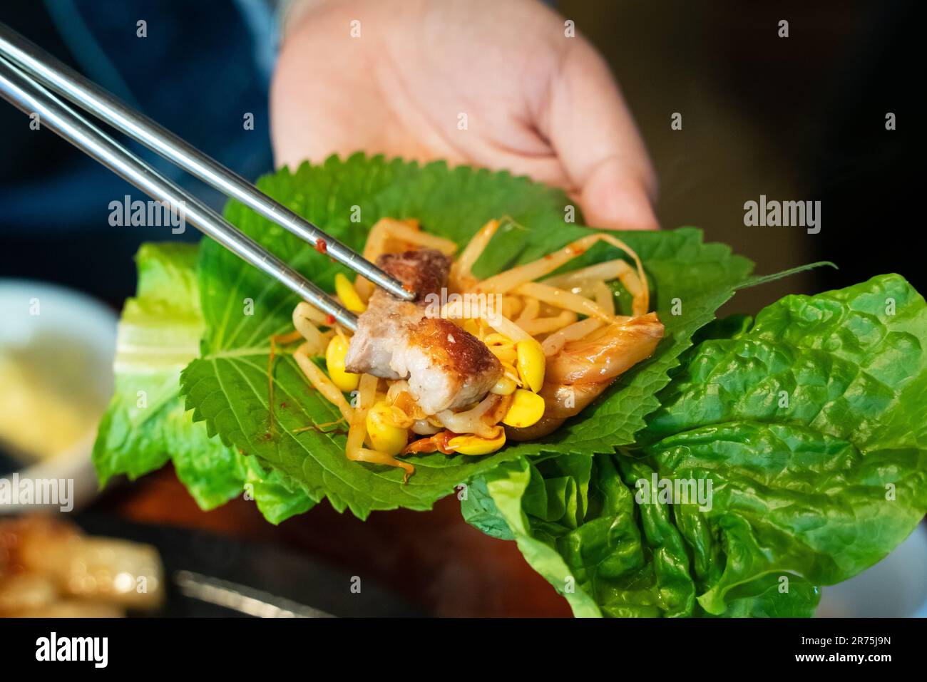 Pan-fried black pork meal in Jeju Korean restaurant, fresh delicious korean food cuisine on iron plate with lettuce, kimchi, banchan and sauce, lifest Stock Photo