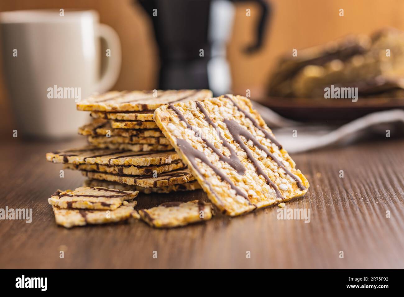 Puffed corn crackers chocolate covered on the wooden table. Stock Photo