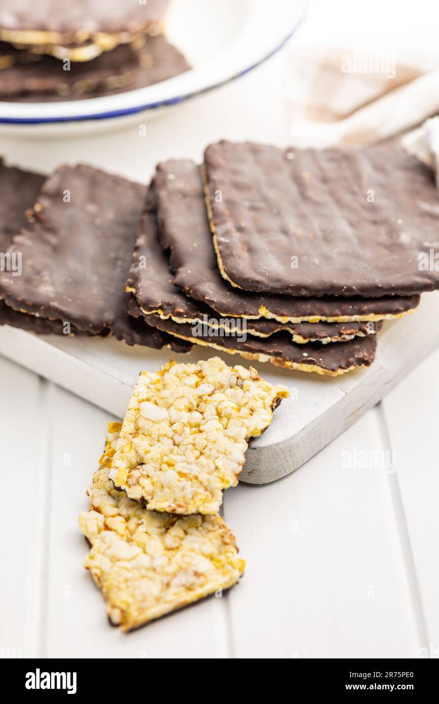 Puffed corn crackers chocolate covered on the white table. Stock Photo