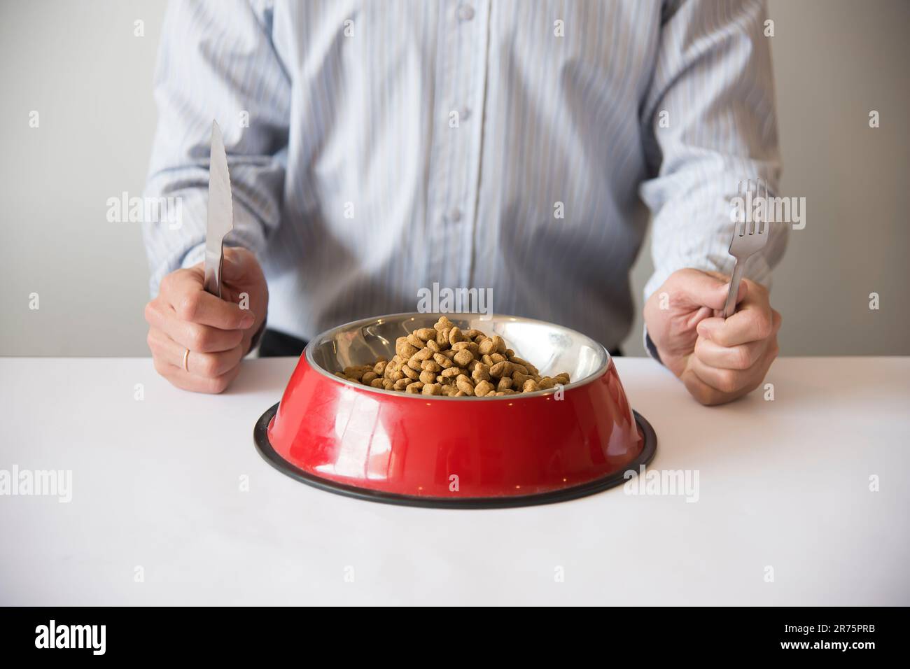 Man eating dog food Stock Photo Alamy