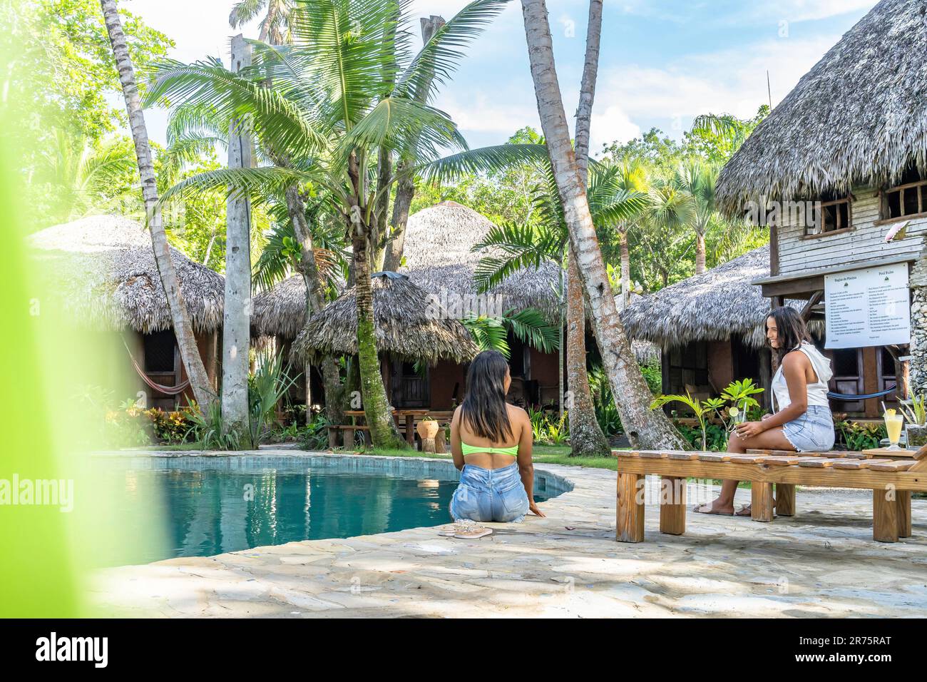 North America, Caribbean, Greater Antilles, Hispaniola Island, Dominican Republic, North Coast, Puerto Plata Province, Cabarete, Two pretty women relaxing at the pool of the boutique hotel Natura Cabana Stock Photo