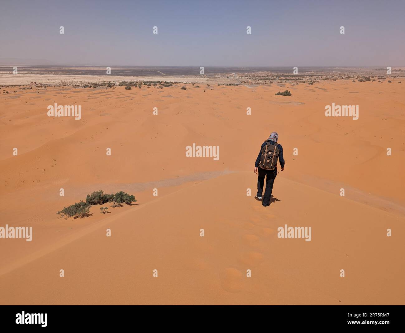 Hiking up the Great Dune of Merzouga in the Erg Chebbi desert, Moroccan ...