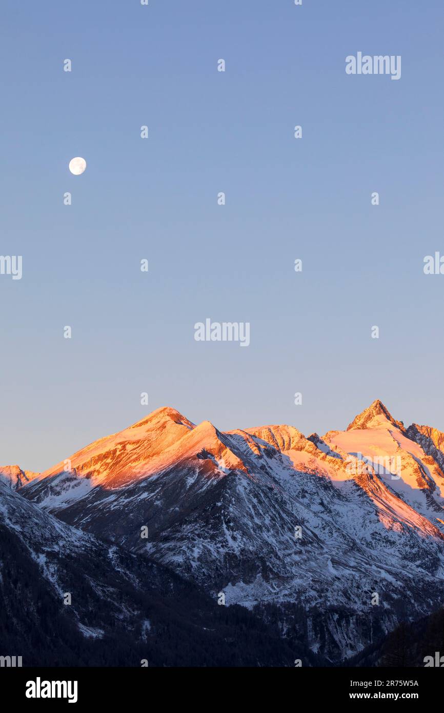 Sunrise at Großglockner, mountain range with moon, alpenglow Stock Photo