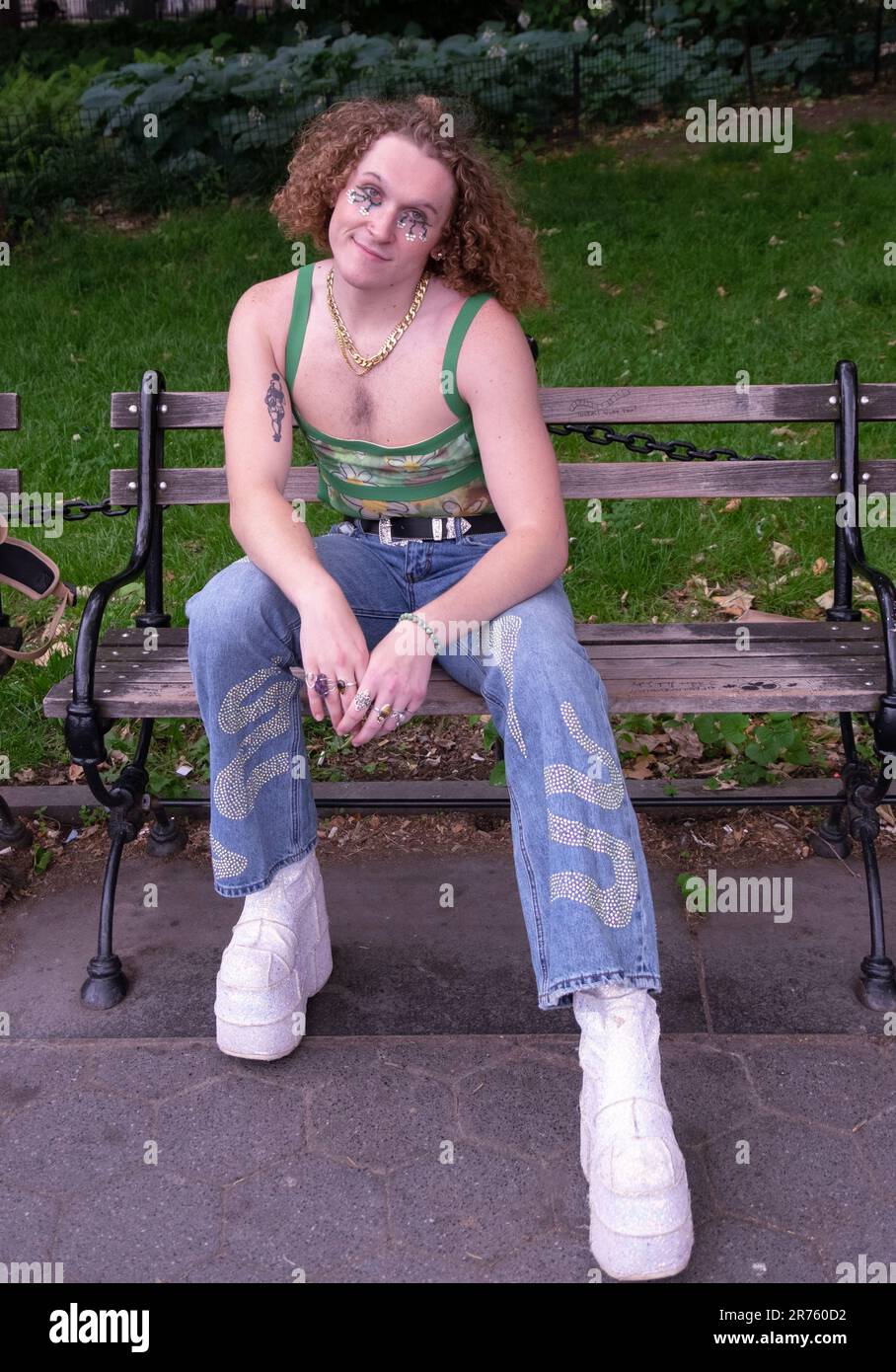 A young man with an individual fashion style and who identifies as he/him poses for a photo in Washington Square Park in Manhattan, New York City. Stock Photo