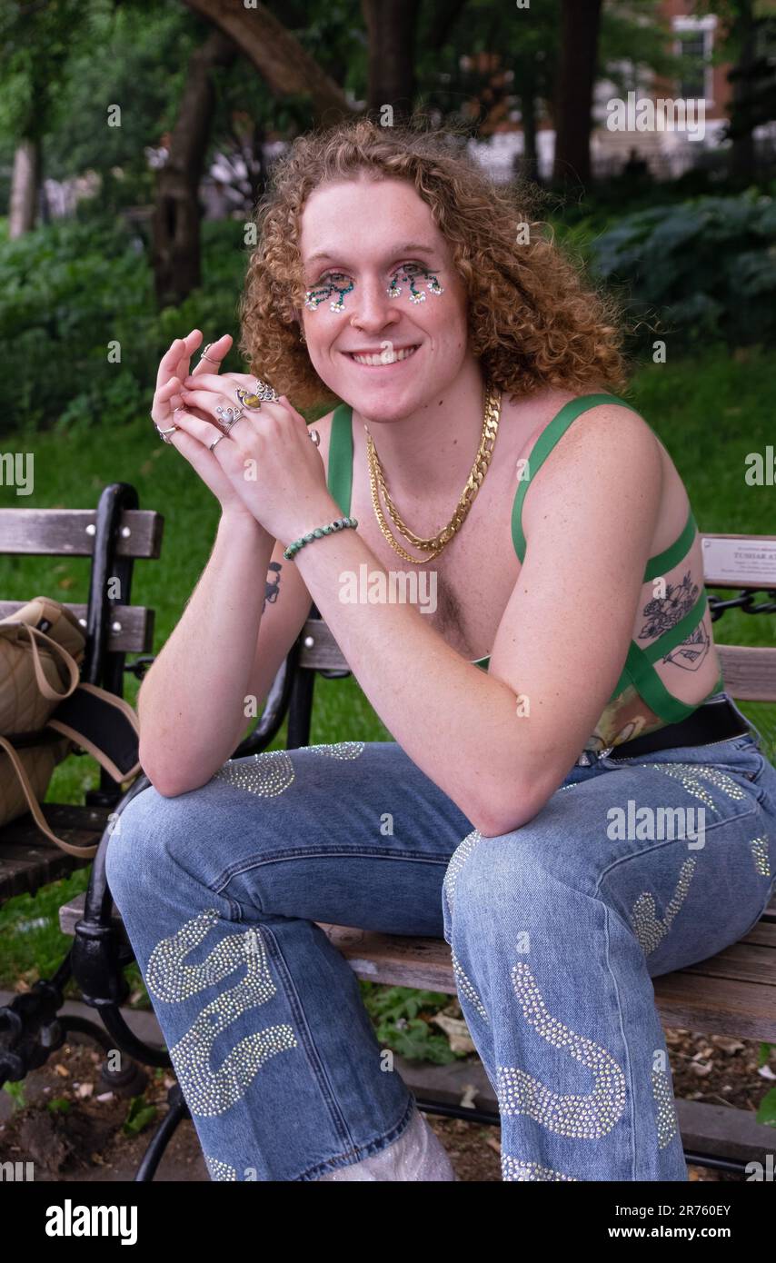 A young man with an individual fashion style and who identifies as he/him poses for a photo in Washington Square Park in Manhattan, New York City. Stock Photo