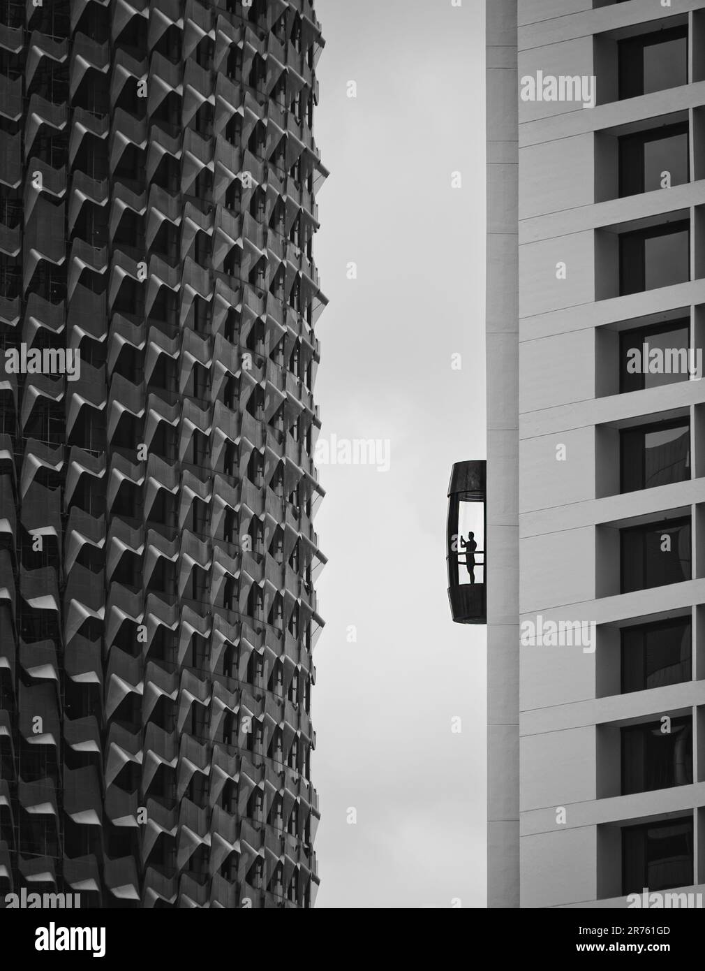 A contemporary cityscape featuring a large, glass elevator next to a