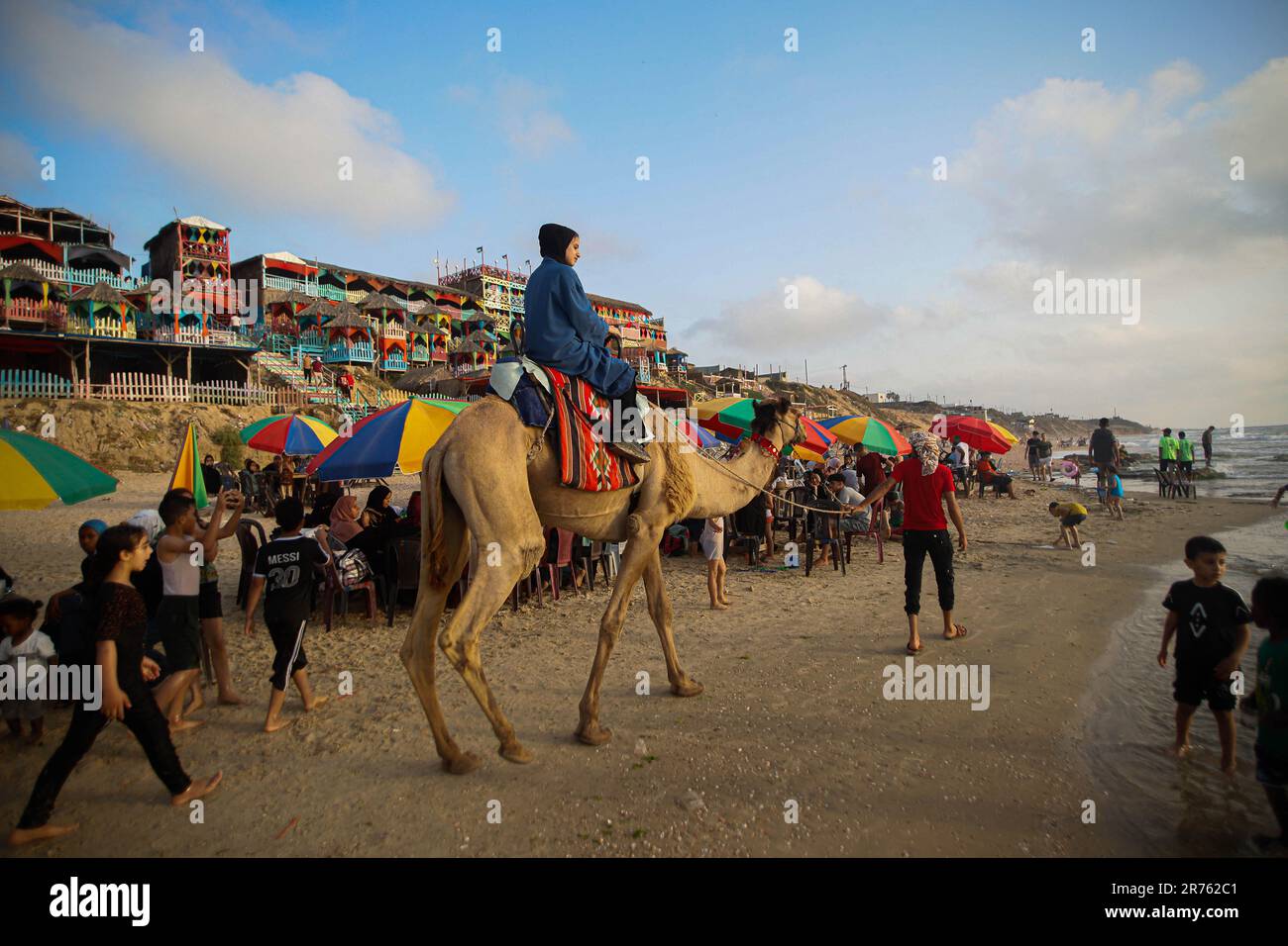 Gaza, Palestine. 13th June, 2023. Kids ride on a camel at the beach in ...