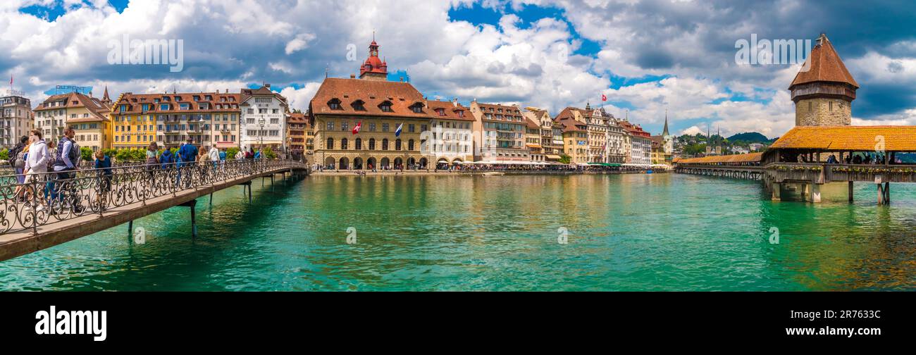 Lovely huge panorama picture of Lucerne's old town boulevard along the river Reuss with people on the bridge Rathaussteg and the famous Kapellbrücke... Stock Photo