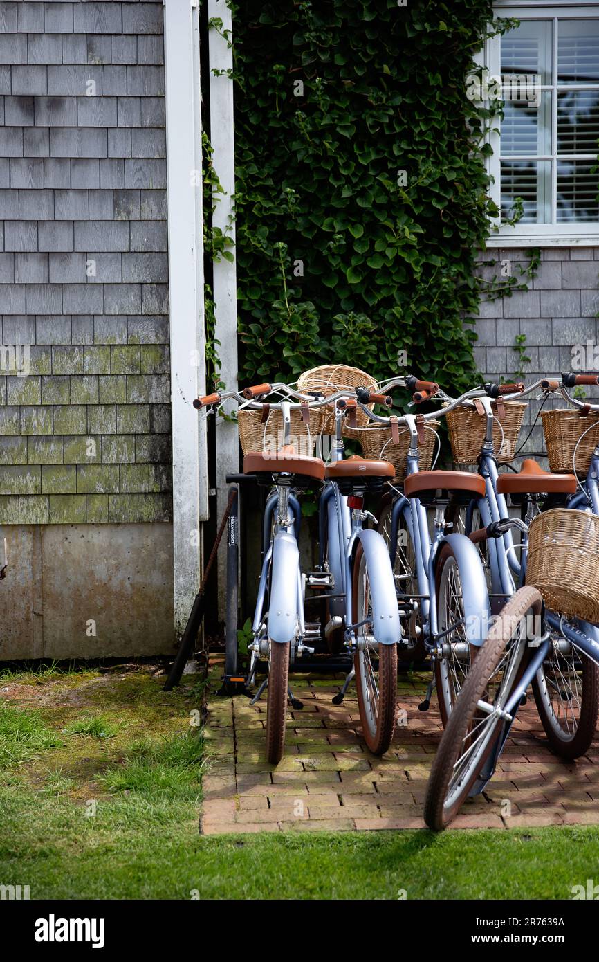 Beach cruiser bikes with baskets stand in a row outside a Nantucket