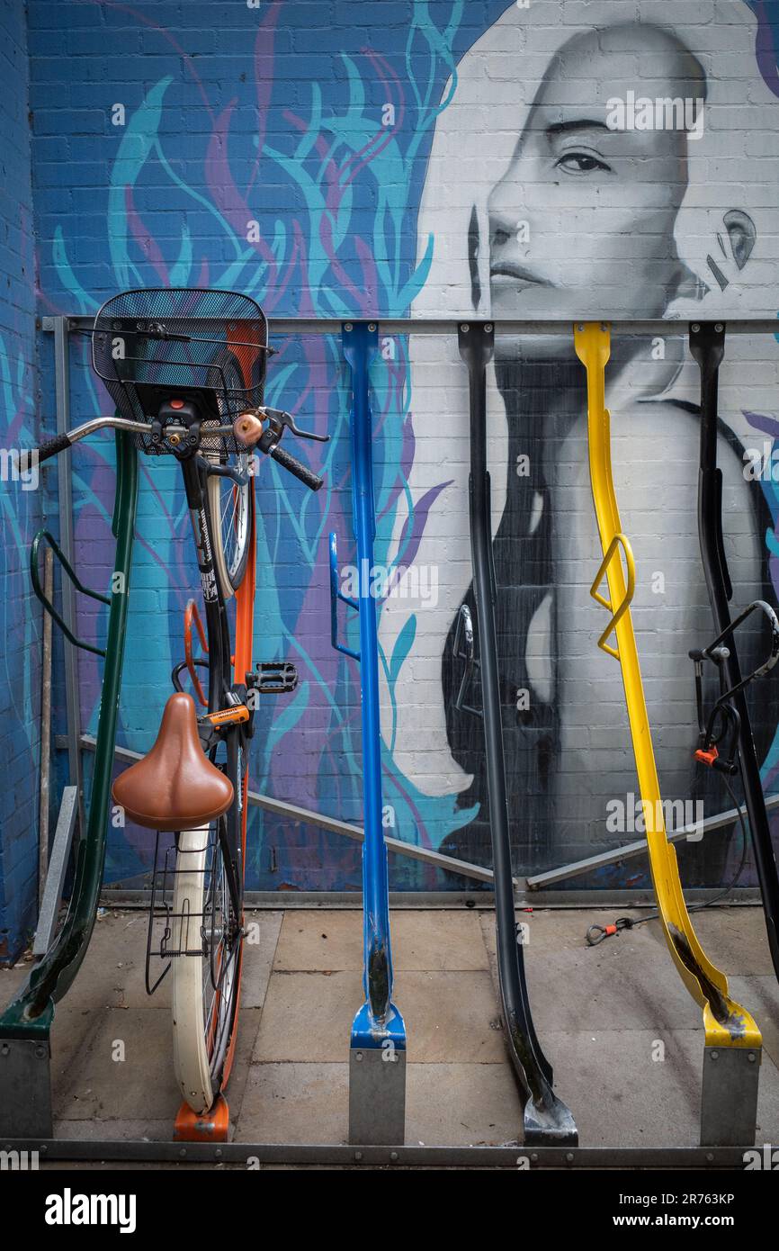 A single bicycle parked in a colourful urban bike rack. Lifestyle, health and fitness or environmental concept. Stock Photo