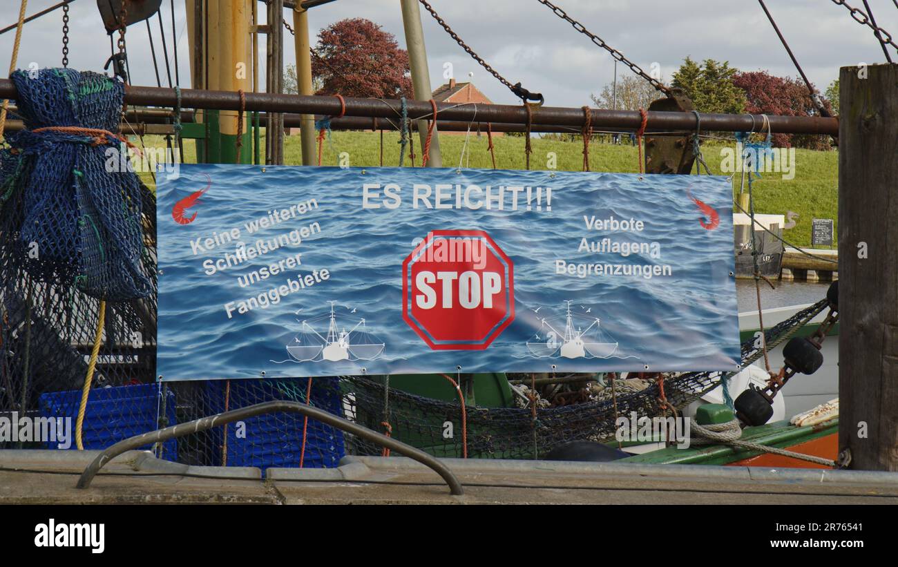 A banner, sign in the Harbor of Greetsiel protesting against a planned ban of bottom trawls Stock Photo