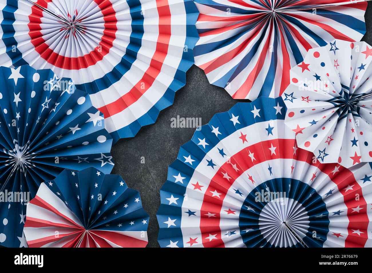 4th of July background. USA paper fans, Red, blue, white stars, balloons, gold confetti on gray dark concrete background. Happy Labor, Independence or Stock Photo