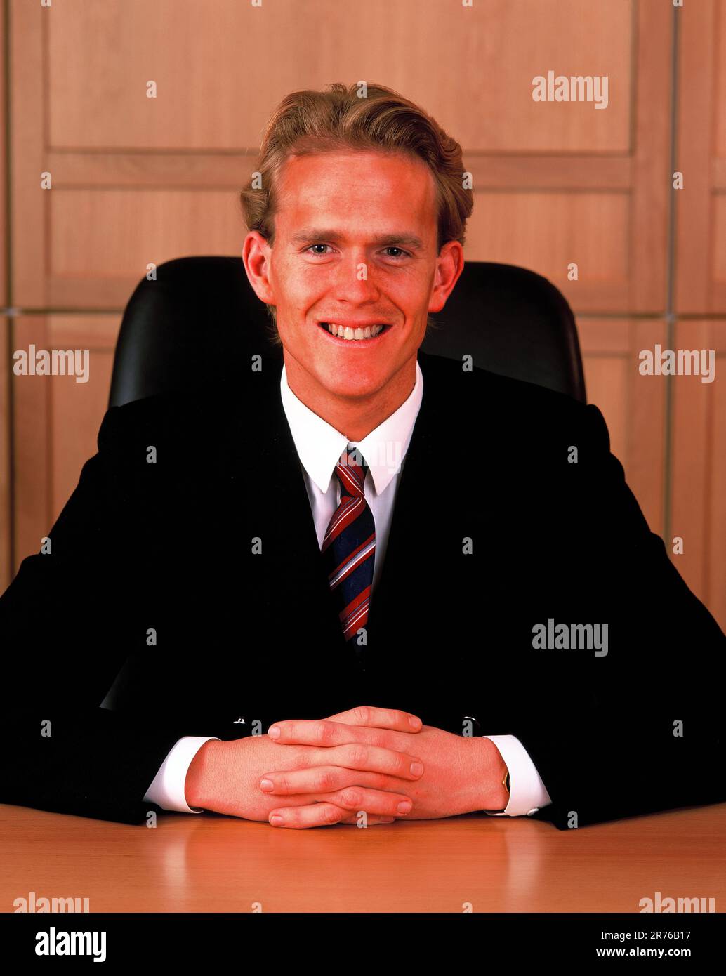Young man business executive indoors, sitting at his office desk. Stock Photo