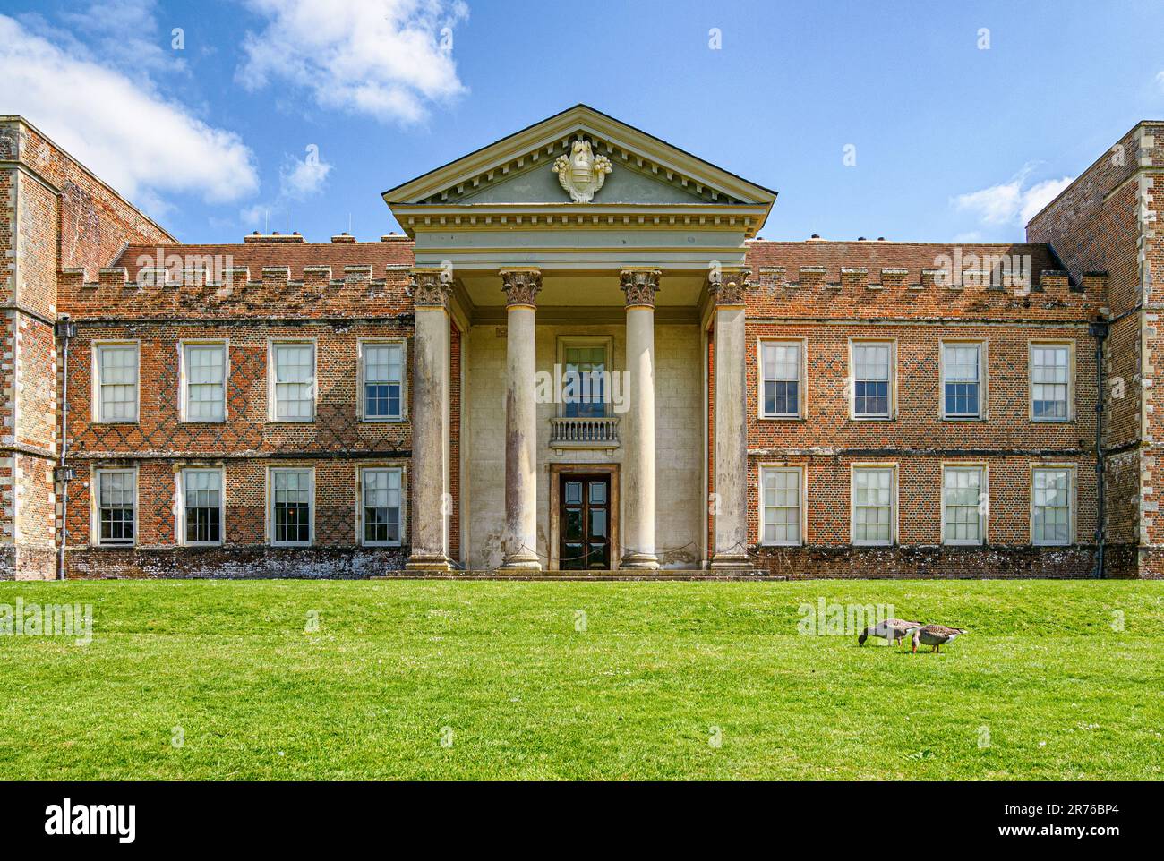 Facade of The Vyne in Hampshire UK with its castellated red brick Tudor buildings and later Corinthian portico Stock Photo