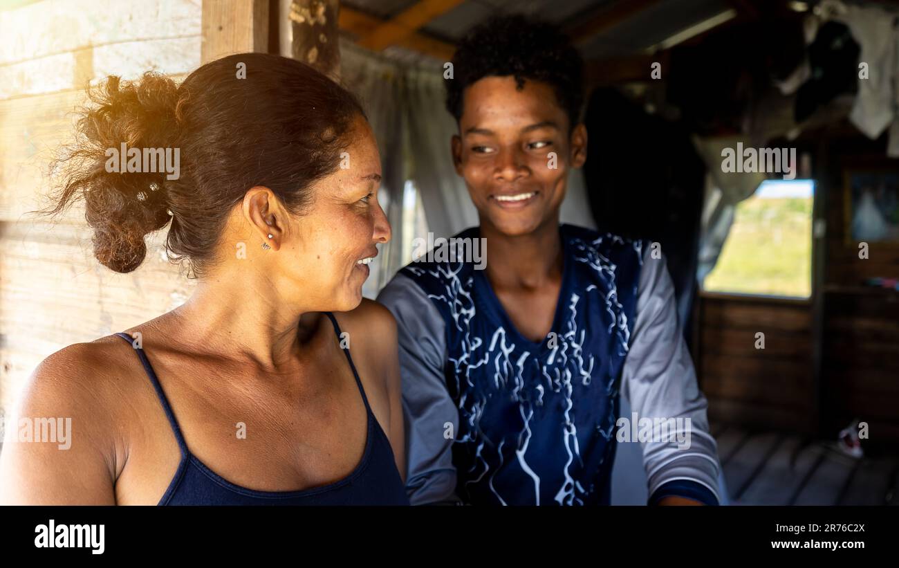 Indigenous mother watching her son smiling in a daily scene of the local family's day-to-day life in the Caribbean Stock Photo